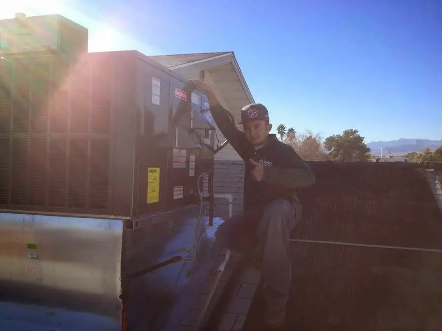 HVAC technician performing Boiler Repair on a rooftop unit in Batavia